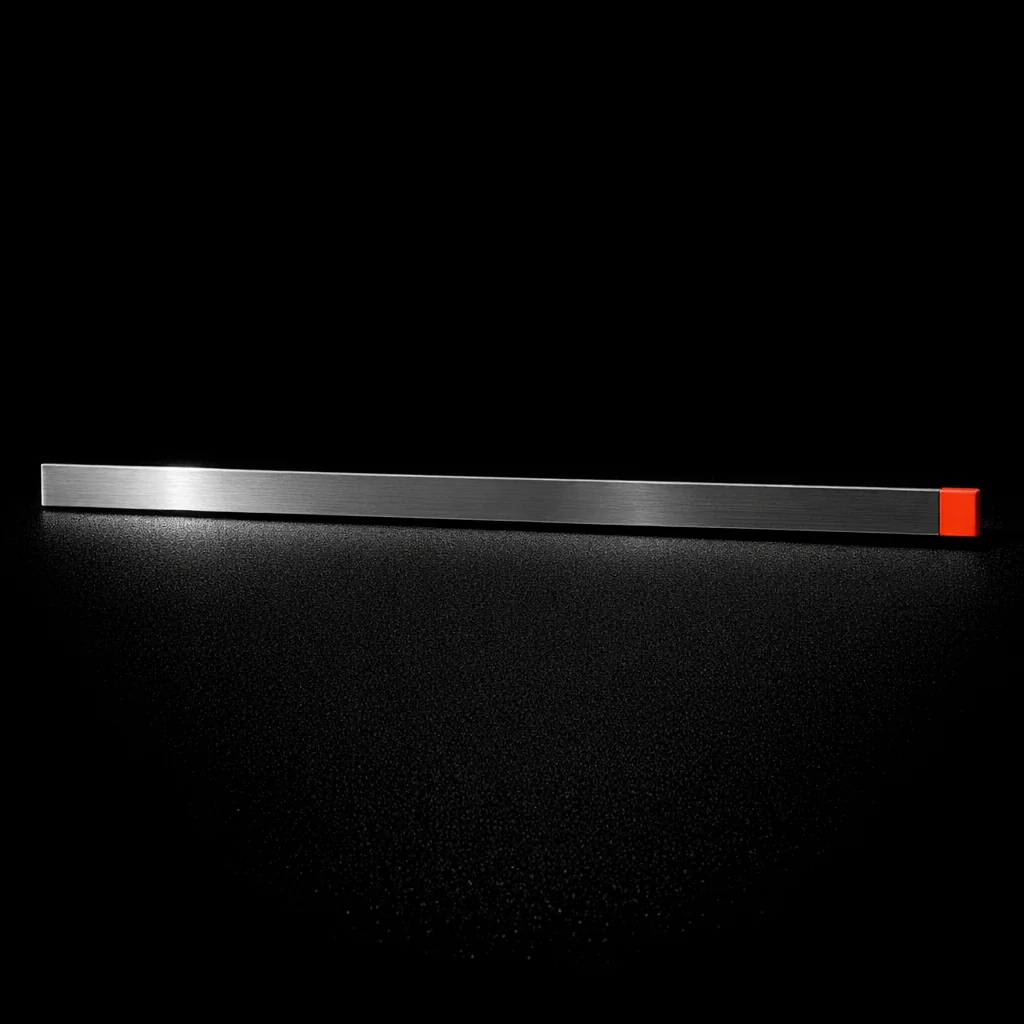 A plain steel machinist ruler laid flat with a matte vermillion end-cap, illustrating bonus wagering contribution rates on non gamstop slots